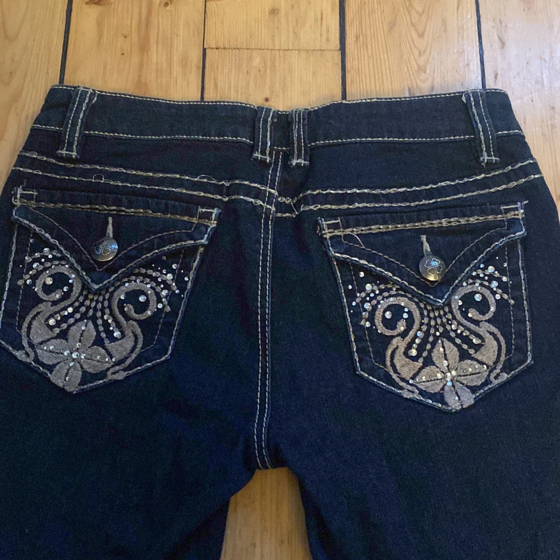 Lowwaist bootcut jeans med broderier på fickorna