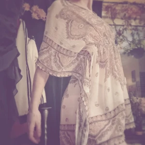 Tun och behagligt strandplagg i rosa 70-tals mönster  - Mycket skön, praktisk och fin material att bära till stranden, badplatsen eller där man ligger och solar. Det är ett halv genomskinligt tyg men rosa 70-tals mönster på hela plagget. Väldigt sött. Det är knappt använt och är i stl. S från new Yorker. 