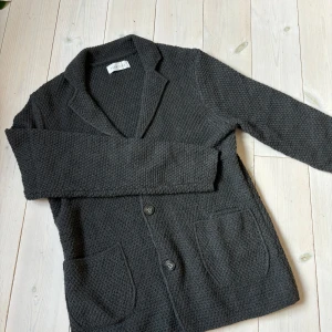 Stickad Kofta - Skön stickad kofta/cardigan. Den är i storlek M och i en snygg grå färg. Hör av er om ni har några frågor!!