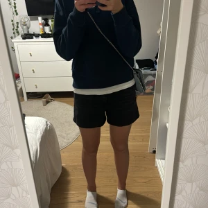 Svarta shorts - Säljer ett par svarta shorts i normal passform. Perfekta för sommardagar eller avslappnade tillfällen. De är enkla och stilrena, vilket gör dem lätta att matcha med olika outfits. Passar bra till både vardag och fest.
