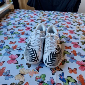 Svartvita fotbollsskor från Nike - Säljer ett par snygga svartvita fotbollsskor från Nike. De har ett coolt sicksackmönster och snörning för perfekt passform. Skorna är i nyskick och perfekta för både träning och match. Köpde dessa för 800kr. Kom gärna med pris förslag lägsta pris 350