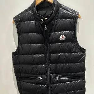 Äkta svart Moncler gui väst köpt från Moncler butiken i Stockholm. (Org.pris 8985kr) Inga skador alls, mycket bra skick (9/10). Kvitto finns även. Tveka inte på att höra av er vid frågor. Vid snabb affär kan priset diskuteras.🤝🤙