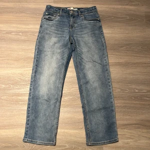 Blå Levi's Jeans - Säljer ett par blå Levi's jeans i väldigt bra skick. De har en avslappnad passform med raka ben. Storlek 164 cm. Skriv vid några funderingar!