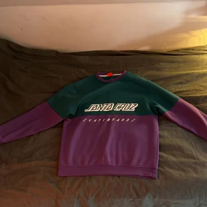 Santa Cruz sweater Medium - Säljer en grön/lila santa cruz tröja använd men bra skick, storlek medium.