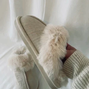 Beige tofflor med pälsdetaljer - Mysiga beige tofflor från Axelda med mjuk pälsdetalj runt kanten. Perfekta för att hålla fötterna varma nu under vintern. Sulan har ett mönster för extra grepp.