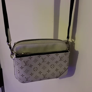 Vit väska LV - Säljer min väska då jag ej använder den. har haft den som prydnad i mitt rum och annars är den använd max 5 gånger.