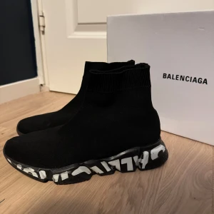 Svarta sneakers från Balenciaqa - Snygga svarta sneakers från Balenciaqa med en unik sula i svart och vit design. Skorna har en strumpliknande passform och är tillverkade i ett stretchigt material för extra komfort.                                                   Kartong medföljs nt.