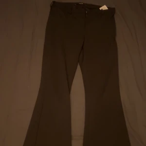 Svarta kostymbyxor - Snygga svarta kostymbyxor med bootcut-stil. Perfekta för en stilren look. Byxorna har en klassisk design med knappar och dragkedja framtill. Köpta på Vero Moda för 399. Nästan aldrig använda då dom är för små