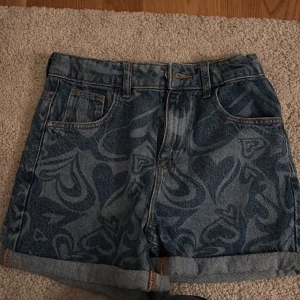 Mönstrade jeansshorts - Snygga jeansshorts med hjärtmönster från Denim Co. Dessa shorts har en klassisk femficksdesign och är perfekta för en avslappnad stil. De är högmidjade och har uppvikta benslut för en trendig look.