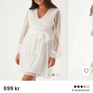Jättefin student klänning/avslutningsklänning  - Elegant vit kortklänning i chiffong med långa ärmar och v-ringning. Klänningen har ett knytband i midjan som ger en fin siluett. Perfekt för sommarens festligheter.