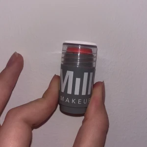 Milk Makeup Lip + Cheek Stick - Milk Makeup Lip + Cheek Stick i en härlig korallrosa nyans. Denna multifunktionella produkt kan användas både som rouge och läppstift. Kompakt och lätt att ta med sig, perfekt för en snabb touch-up när som helst. Använd två-tre gånger och säljer för ingen andbändning, har inte akne eller hudproblem.