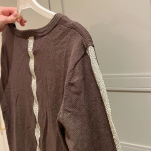 Brun kofta från Culture - Säljer en brun kofta från Culture med knappar framtill och glittriga ränder längs ärmarna och ryggen. Den har en rund halsringning och långa ärmar. Aldrig använd❤️