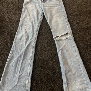 Blå jeans med slitningar - Säljer ett par blå jeans med slitningar på knäet. Jättebra skick förutom de man ser på sista bilden 