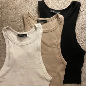 Ribbade toppar från Zara - Säljer tre ribbade linnetoppar från Zara i färgerna svart, beige och vit. Passform på andra bilden. Säljer alla 3 för 70kr. Använt skick men inga defekter. Storlek S på alla tre.