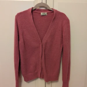 Rosa kofta från Acne Studios - Säljer en cardigan från Acne Studios model Lesley Angora, i djup rosa färg och med dolda tryckknappar. Mjukaste materialet av 70% angora och 30% nylon, inte alls stickig! Är i så fint skick, är nästan inte använd.  Storlek L men är åt det mindre hållet så skulle säga att den snarare passar en M/38:)