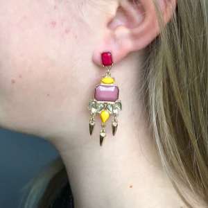 Färgglada örhängen med gulddetaljer - Säljer ett par unika och färgglada örhängen med gulddetaljer. De har en mix av rosa, röda och gula stenar! ✨️🎀 Vet ej vilket material de är gjorda av!