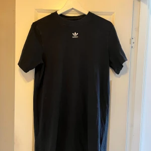 T-shirtklänning från Adidas - Säljer en skön Adidas-klänning med tryck på ryggen.🫶🏻 Den är använd många gånger men är i gott skick. Hör av er för fler bilder eller om ni har frågor🫶🏻