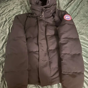 Canada Goose Macmillian  - Säljer nu en canada goose macmillian jacka i bra skick. Storleken är L. Det finns bara en liten fläck som bara syns med flash men det lägger man inte märke till. Ställ gärna frågor. Obs inte äkta!!