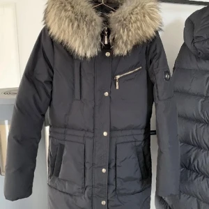 Hollies jacka Les arcs - Snygg, varm och funktionell vinterjacka i ett vattenavstötande materiel med en 100% äkta tvättbjörns päls! Jackan har gulddetaljer och är använd men i bra skick! Priset kan diskuteras✨✨