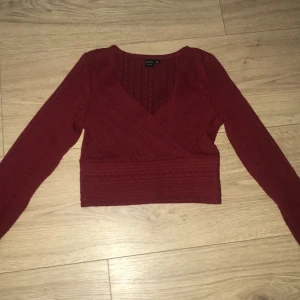 Långärmad tröja - En jättesnygg v-ringad vinröd tröja i ett otroligt snyggt mönster. Elastisk runt midjan med väldigt bra passform. Från SHEIN SXY i storlek xs. En snygg tröja som passar fester men även i vardagen om man vill se extra snygg och glamourös ut.