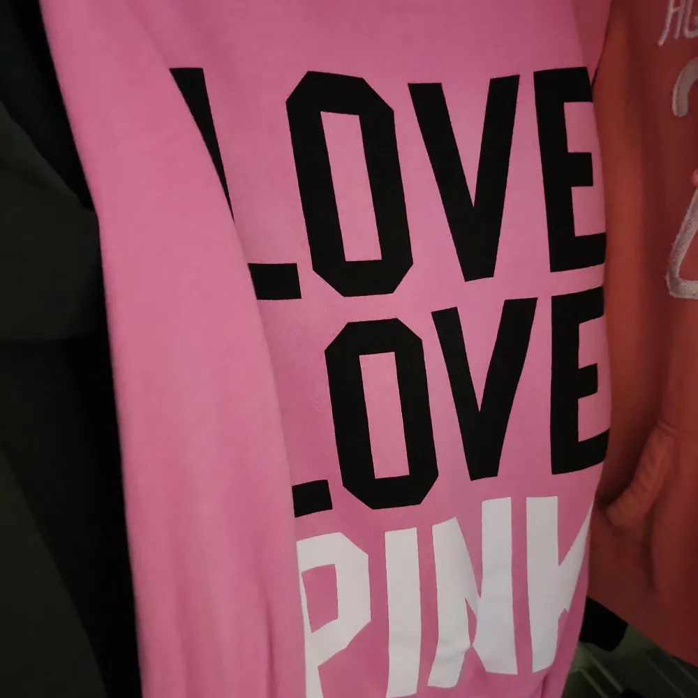 Säljer en superfin rosa hoodie från Victoria's Secret PINK. Den har en dragkedja framtill och en luva med vita snören. På ryggen står det 'LOVE LOVE PINK' i stora bokstäver. Perfekt för en mysig dag eller en avslappnad stil. 🩷 . Tröjor & Koftor.