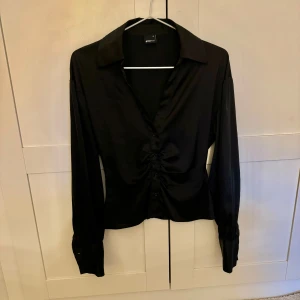 Svart satinblus - Svart satinblus från Gina i strl XS! Köpt nyligen men lite för liten tyvärr, i nyskick!
