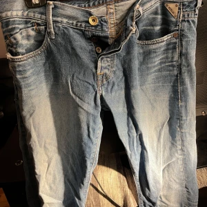 Unika jeans från Replay - Snygga blå jeans från Replay med klassisk femficksdesign och knappgylf. De har en cool tvättad look och Replay-logga på fickan. Perfekta för en avslappnad stil. Vintage stil som inte säljs i butik!
