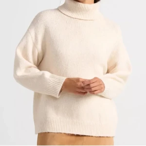 Beige stickad polotröja - Mysig beige stickad polotröja med långa ärmar och ribbade muddar. Perfekt för kyliga dagar med sin klassiska design och bekväma passform.