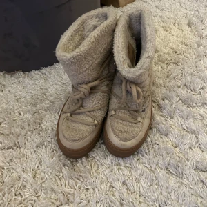 Beige boots med snörning - Säljer ett par mysiga beige boots med snörning och teddyfoder. Perfekta för kalla dagar med sin varma och bekväma design. De har en robust sula och är gjorda i ett mjukt material som ger en skön passform. Liknar det skor från Iniuki🩷