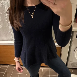 Mörkblå kashmirtröja från Soft Goat - Säljer en elegant mörkblå kashmirtröja från Soft Goat. Tröjan har en figursydd passform med långa ärmar och en rund halsringning. 