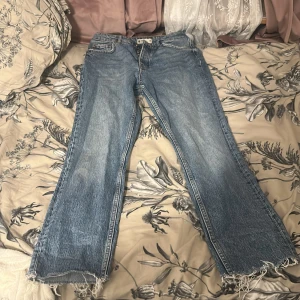 Blå Gina Tricot jeans  - Säljer ett par klassiska blå jeans från Perfect Jeans. De har en rak passform med slitna detaljer vid fållen och knappar i gylfen. Storlek 36/S. Använda en gång. Köpa för 600kr