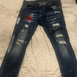 Blå jeans från Dsquared2 - Snygga blå jeans från Dsquared2 med coola slitningar och tryckdetaljer. Tillverkade i Italien. Storlek 46