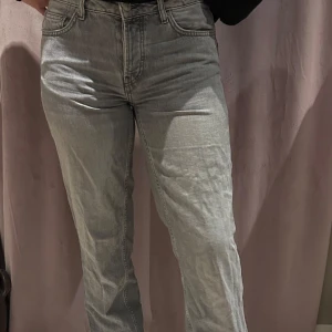 Grå jeansbyxor - Snygga grå jeansbyxor med en klassisk design. De har en rak passform och är perfekta för en avslappnad stil. Byxorna har fem fickor och en knappgylf.