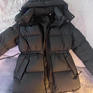 Svart dunjacka från GANT - Säljer en svart dunjacka från GANT i storlek XS. Jackan har en dragkedja framtill och en justerbar midja för bättre passform. Be om bild för att se passform! 🩵Köpt för 5000 kr från GANT hemsida 