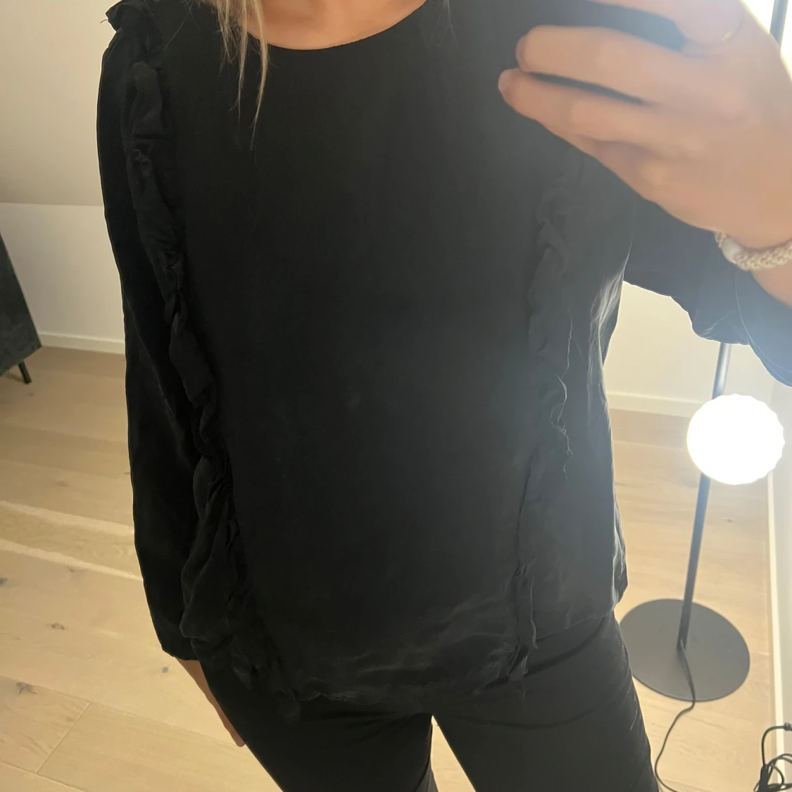 Svart blus med volangdetaljer