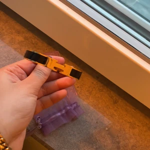 Svart och guld färgad armband - Elegant armband i svart och guld med en stilren design. Armbandet har en glänsande finish och är perfekt för att ge en touch av lyx till din outfit.