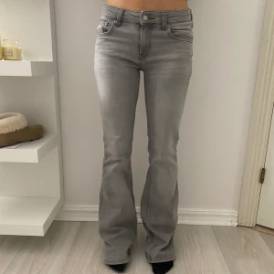 Gråa bootcut jeans ifrån Lager 157 - Säljer dessa gråa lågmidjade/mid bootcut jeansen ifrån Lager 157. Storlek XS/Full. Hon på bilden är 164