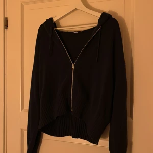 mörkblå hoodie från BikBok - Säljer en mörkblå hoodie från BikBok i storlek XS. Den har en dragkedja framtill och en mysig huva. Perfekt för en avslappnad stil. Hör av dig vid intresse!