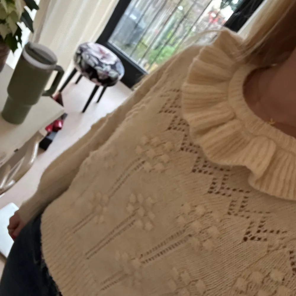 Säljer en söt beige stickad tröja med volangdetalj vid halsen. Tröjan har ett fint mönster och långa ärmar. Storlek 164 från Zara men passar som XS/S.. Neuletakit & Villapaidat.