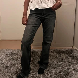 Svarta jeans med paljettdetaljer - Snygga gråa jeans med en utsvängd passform och coola paljettdetaljer på bakfickan. Perfekta för att ge din outfit lite extra bling. De har en klassisk design med fem fickor och knappgylf. Lågmidjade!