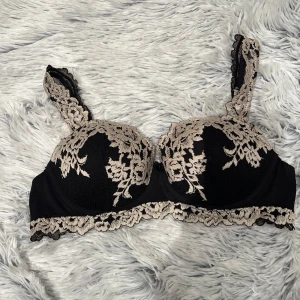 Intimissimi bh  - Svart Intimissimi bh med  beige spetsdetaljering. Den är nästan helt ny, använd fåtal gånger därav priset. Axelbanden är justerbara och dekorerade med spets, jag har även sytt in axelbanden lite men inget som man märker