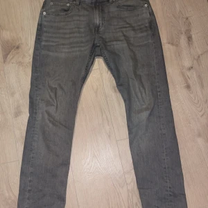 Grå jeans Slimmy från 157 - Snygga grå jeans från 157 i modellen Slimmy. De har en klassisk femficksdesign och en knappgylf. Perfekta för en stilren look.För bättre bilder skriv gärna! Det blev nått fel när jag skulle ladda upp bilderna så det är därför man inte ser hela bilden.