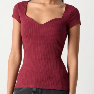 Vinröd topp - Snygg vinröd ribbad topp med korta ärmar och v-ringad. Från Anna field 