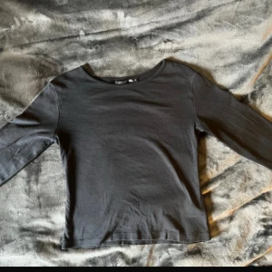 Svart långärmad topp från 157 - Säljer en stilren svart långärmad topp från 157. Perfekt för en enkel och bekväm look. Toppen har en rund halsringning och är tillverkad i ett mjukt material. Storlek S och har bara används några få gånger