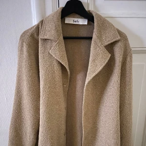 Séfr skjorta - Säljer en stilren beige overshirt från Séfr. Den har en klassisk krage och knappar framtill. Perfekt för lager-på-lager-stil och passar till många olika outfits. Använt 1 gång.