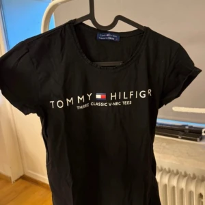 Marinblå t-shirt från Tommy Hilfiger - Snygg marinblå t-shirt från Tommy Hilfiger med tryck framtill. Perfekt för en casual look. Tillverkad i mjukt material för extra komfort.