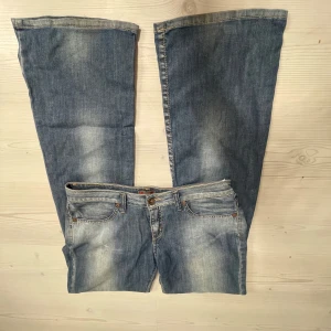 Blå bootcut jeans - Snygga blå bootcut jeans med en klassisk femficksdesign. Jeansen har en lätt tvättad look och stängs med dragkedja och knapp. Midjemåttet 40, Innerbenslängd 84, grenmått 20. Jag är 167💗