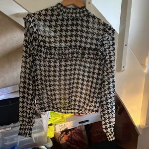 Fin blus med hundtandsmönster - Fin blus från ginatricot med volanger och hundtandsmönstrad. Bara använd vid enstaka tillfällen så i bra skick