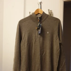 Brun merinoulltröja från Morris - Säljer en helt ny melerad gråbrun Merino John Zip tröja i merinoull från Morris. Perfekt laidback stil med t-shirt eller skjorta under i höst och vinter. Tröjan är helt oanvänd med alla taggar kvar. Storleken är small. Nypris runt 1500 kr.