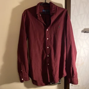 Vinröd skjorta från Ralph Lauren - Säljer en snygg vinröd skjorta från Ralph Lauren i storlek M. Skjortan är i nyskick och det finns inga skavanker. Pris kan diskuteras! Dm om du har frågor